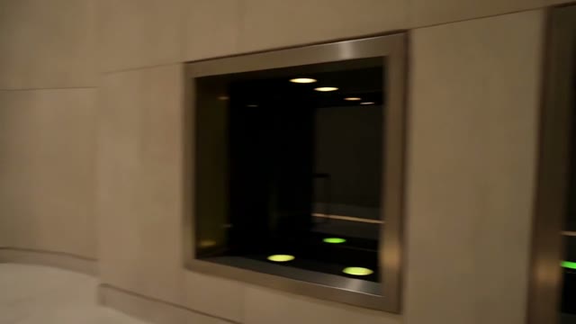 Small green and red access lights beside dark glass service bays